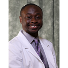 KCU student doctor Reggie Boateng smiles in his white coat. 